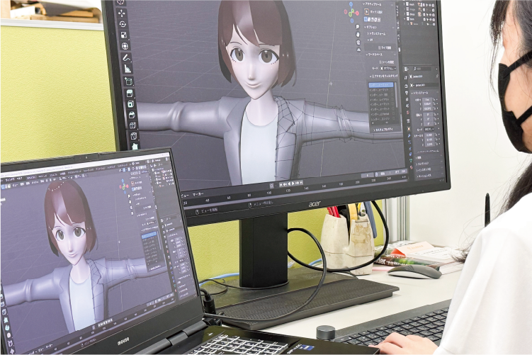 パソコンで3Dキャラクターのモデリングを行う社員
